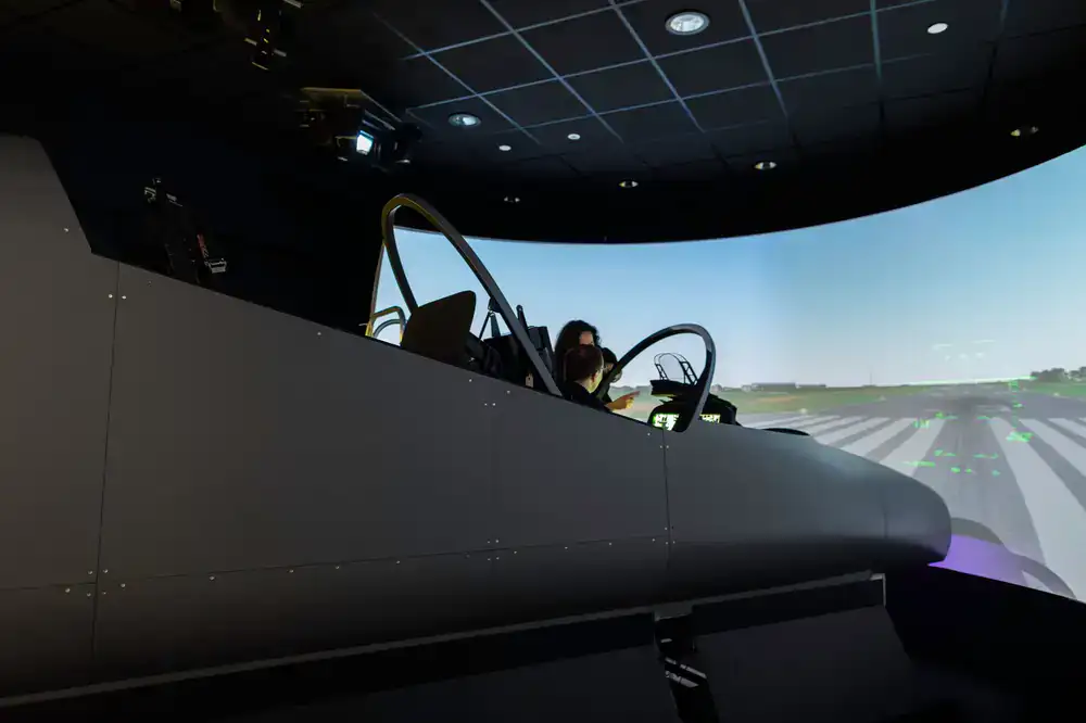 Instructor guiding a guest in the flight simulator